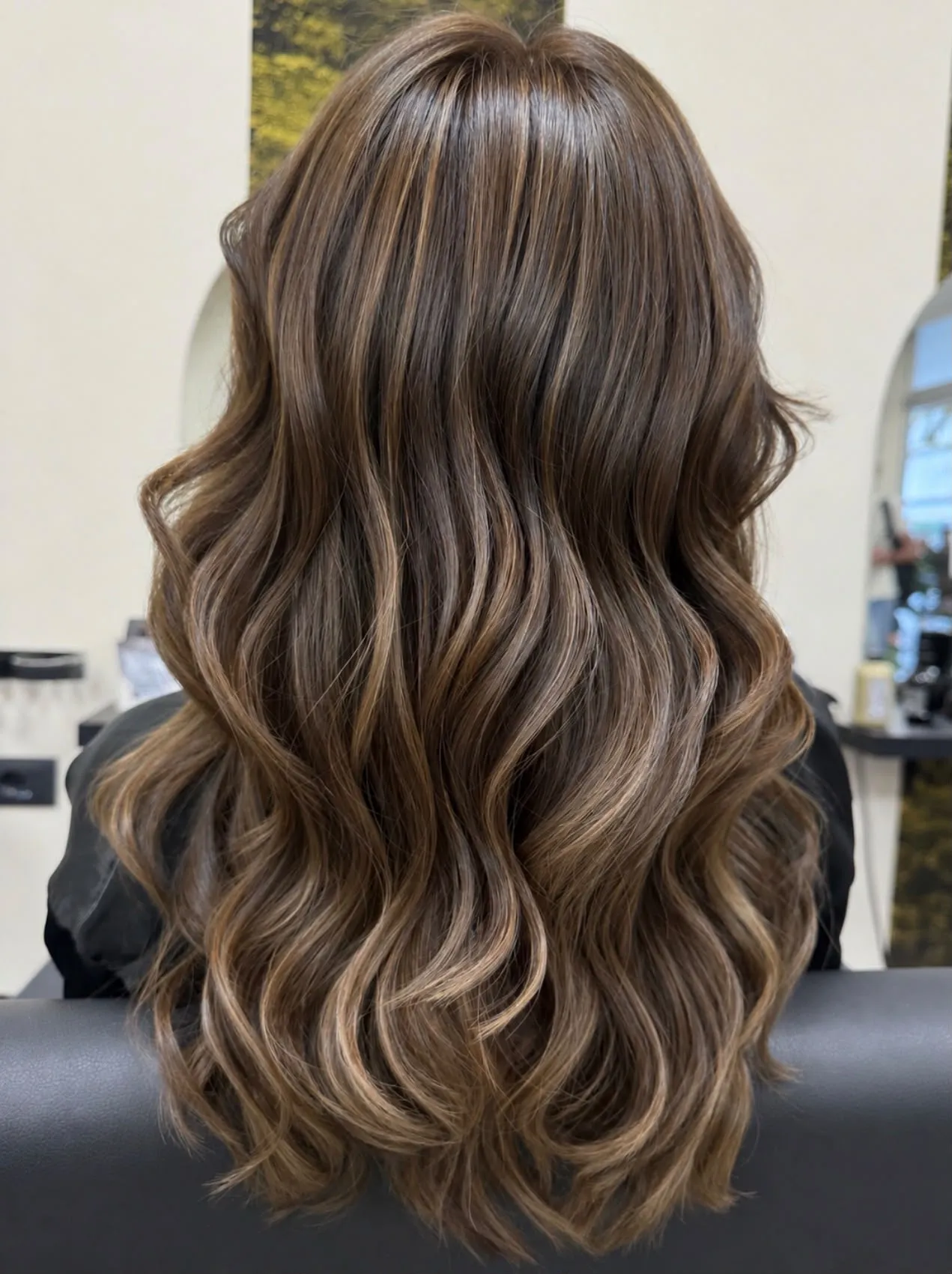 Capelli castani mossi con riflessi caramello, visti di spalle