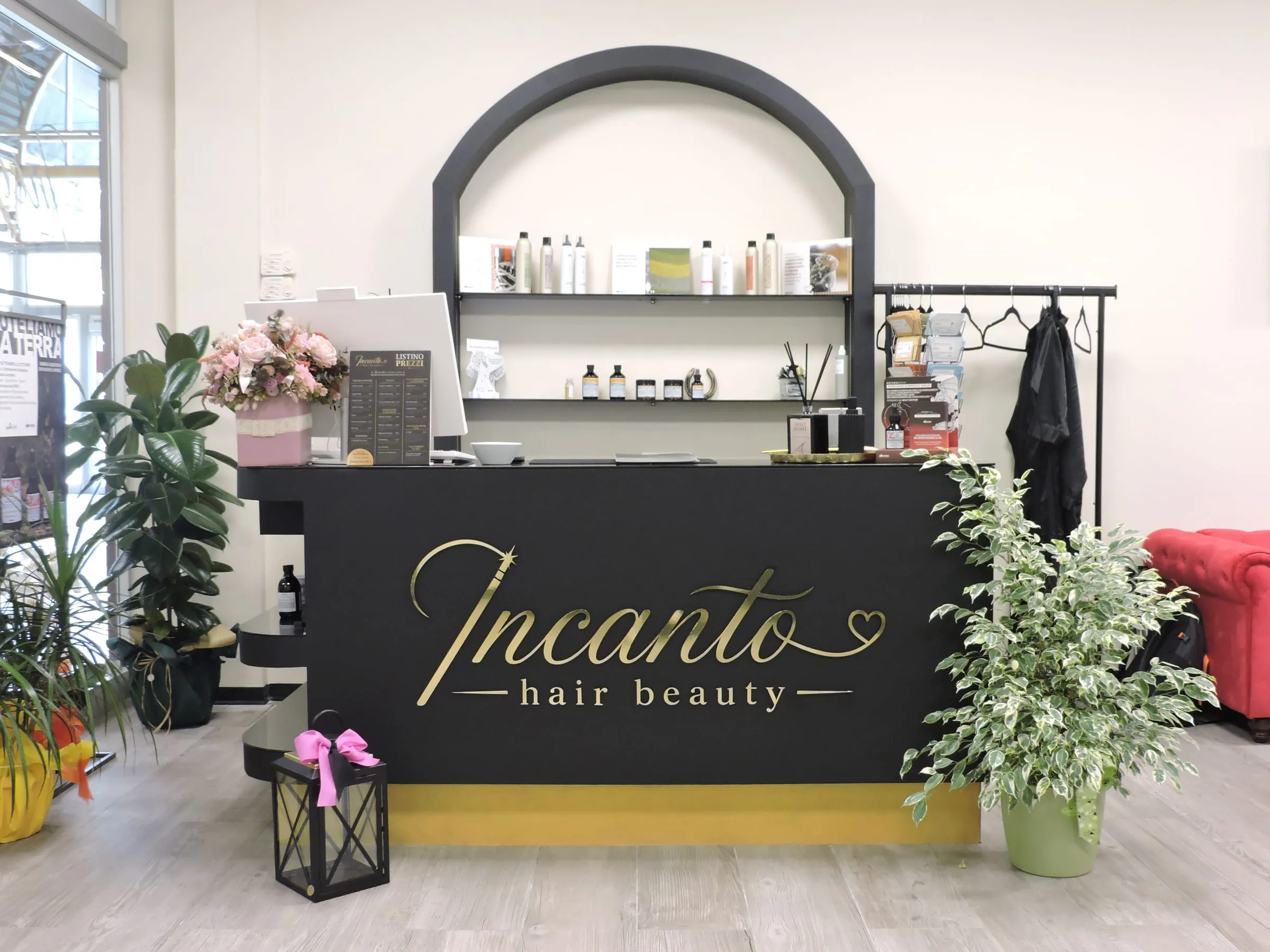 Il bancone nero del salone con la scritta dorata Incanto hair beauty